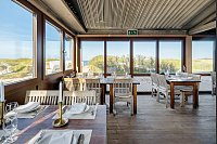 Die großzügigen Fenster ermöglichen einen ungehinderten Ausblick auf die schöne Küsten- und Dünenlandschaft der Nordseeinsel Sylt. - © Architekturfotografie Bach/Schüco