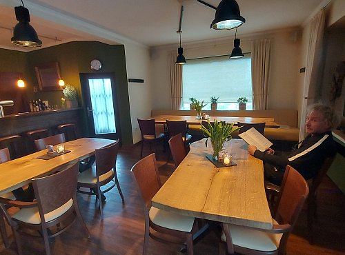 Gast Hans de Jonge stöbert in der Speisekarte des Gasthauses Zurmühlen. Der Gastraum ist vor Kurzem fertig renoviert worden. - © Claus Meyer