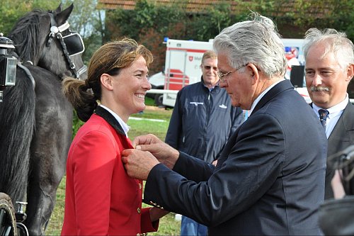 Sönke Sönksen heftet Insa Glanemann, die ebenfalls bei den Reitertagen 2011 für Versmold startet, das Goldene Reitabzeichen für ihre sportlichen Leistungen an. - © Marc Uthmann