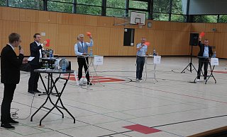 Moderator Tristan Lippold (von links) hat die Kandidaten zur Meinungsbekundung per Karte aufgefordert. Und beim ÖPNV sind sich Michael Meyer-Hermann, Ralf Zurmühlen, Joachim Klack und Knud Schmidt einig: Versmold ist hier noch zu schwach aufgestellt. - Marc Uthmann