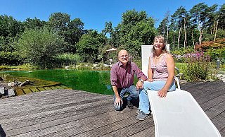 Andreas und Ines Filius aus Lipperreihe neben ihrem großen Naturteich mit einer Tiefe von 2,50 Metern, in dem auch geschwommen werden kann. Neben der Familie nutzen das gerade im Sommer auch Freunde und Nachbarn. - Karin Prignitz