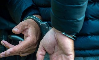 Ein Mann trägt Handschellen. - Stefan Sauer/dpa/Illustration