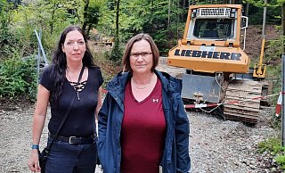 Birgit Lutzer (l.) und Andrea Groß vom BUND vor einem der Radlader, die den großen Reitplatz aufgeschoben haben. Der Zugang zur Reitanlage am Bergkamp ist derzeit gesperrt. - Jonas Damme