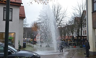 Ein Mitarbeiter der Wasserwerke sucht den Zapfen für den Schieberschlüssel und muss dabei gegen den Druck der Wasserfontäne arbeiten. - Ekkehard Hufendiek
