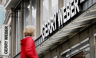 Eine Passantin geht an einer Filiale des Modeherstellers Gerry Weber vorbei. Der Konzern hat der Kette eine erneute Schrumpfkur verordnet. - dpa