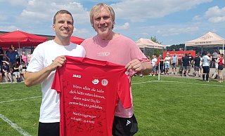 Martin Hagemeyers Zwillingsbruder Thomas (l.) und Ex-Profi Ansgar Brinkmann zeigen das Trikot, auf dem die Mitspieler von TG Hörste und SV Häger unterschrieben haben. - Sven Hauhart