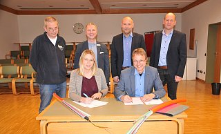 Bürgermeisterin Sarah Süß und Andreas Schulz (Leiter Standort- und Oberflächenmanagement bei der Telekom) unterschreiben die Absichtserklärung. Dahinter, von links: Dirk Gaßdorf und Jens Hahn von der Gemeindeverwaltung sowie Frank Thamm und Kai Fischer von der Telekom. - Frank Jasper
