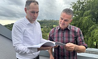 Vor dem Hintergrund der Haller Egge werfen Marcel Räker (l.) und Achim Lantzke von der Bürgerinitiative noch einmal einen Blick in die 43-seitige Stellungnahme, die sie an den Kreis Gütersloh geschickt haben. - Heiko Kaiser