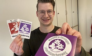 Dominic Rudek, im Rathaus unter anderem für den Tourismus zuständig, hat Aufkleber zum Leberblümchenweg und zum Hexenpatt drucken lassen. - Frank Jasper
