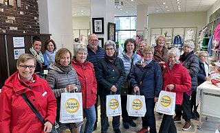 Mit Stefanie Krumkühler (l.) ist diese gut gelaunte Damengruppe samt Herr am Samstagmittag auf besonderer Stadtführung in der Geschäftswelt unterwegs. Auch im Modehaus M1 gibt es ein Stück Versmold in die Heimatshoppen-Tüte - sowie Kaffee und Kuchen. - Tasja Klusmeyer