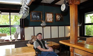 Frank Goretzki im Schankraum von Wietes Wirtshaus. Charmante Details wie Teekannen-Lampen und eine alte Bahnhofsuhr sorgen für Hingucker. Genau wie zahlreiche Tierbilder, die seine Frau Heike Deininger gemalt hat. - Anja Hanneforth, HK