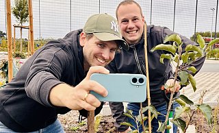 Ein Erinnnerungsfoto für die eigene Fotogalerie: Dennis Bleck (l.) und Andre Schneider vom "Haller Kreisblatt" haben die Baum-Challenge erfüllt und einen Apfelbaum am Wiedenfeld in Peckeloh gepflanzt. - Timo Kirchhoff