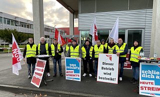 Ein Teil der Streikenden hält vorm Werktor der HN Produktion die Stellung. Die übrige Frühschicht am Versmolder Standort der Zur-Mühlen-Gruppe ist im Streiklokal zusammengekommen. - Tasja Klusmeyer