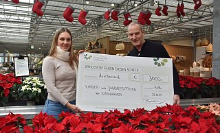 Mareike Schöne, die im Steinhagener Rathaus die Kinder- und Jugenstiftung betreut, nimmt von Henry Brockmeyer in seinem Haller Gartencenter einen Spendenscheck in Höhe von 3.000 Euro entgegen. - Birgit Nolte