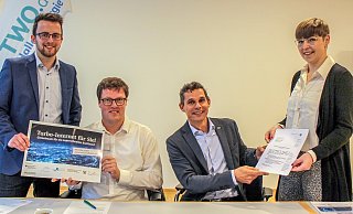 Meilenstein im Haller Breitbandprojekt: Maurice Kleffel (links) und  Katharina Fiebig (rechts) von der Geschäftsstelle Gigabit.NRW (Detmold) überbringen Jochen Strieckmann (Zweiter, von links) und Johannes Wiese das wertvolle Papier persönlich. Denn es ist höchste Zeit, dass mit dem Bau des Haller Gigabit-Netzes begonnen werden kann. - Stadt Halle