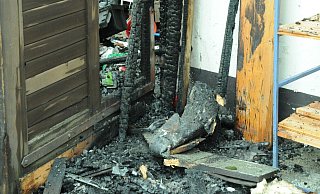 Im unteren Bereich des Holztors ist das Feuer vermutlich ausgebrochen. Die davor stehenden Holzlatten sind komplett verkohlt. - Heiko Kaiser