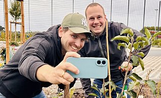 Ein Erinnnerungsfoto für die eigene Fotogalerie: Dennis Bleck (l.) und Andre Schneider vom "Haller Kreisblatt" haben die Baumchallenge erfüllt und einen Apfelbaum am Wiedenfeld in Peckeloh gepflanzt. - Timo Kirchhoff