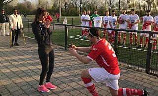 Steinhagens Stefan Valjarevic macht seiner Freundin Maria vor dem Landesliga-Spiel gegen Neuenbeken einen Heiratsantrag. Im Hintergrund hat sich der Rest des Teams in weiße T-Shirts geschmissen. - Christian Helmig