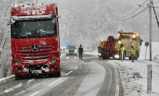Der Auflieger des roten Lkw hängt schon halb am Hang. Der gelbe Abschlepper muss warten, da die Situation aktuell sehr brisant ist. - Peter Unger