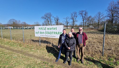 Das Banner am Zaun des Geländes ist zwar schon zwei Jahre alt, die Botschaft ist jedoch geblieben. Dennoch zieht sich die Stadtpark-Initiative Halle, federführend bestehend aus Hartmut Lüker (v. l.), Gisela Bültmann, Werner Landwehr und Kai Thöne, nun zurück und sieht das Projekt auf einem guten Weg. - © Uwe Pollmeier