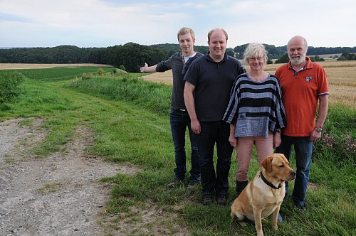 Da soll es hin: Dennis, Sebastian, Dorothee und Hans-Jürgen Surmann (von links) möchten auf der Fläche östlich der Rotenhagener Straße, dort, wo sich links vor dem Waldstück das abgemähte Kornfeld befindet, ein Windrad errichten. Die erforderlichen Gutachten sind inzwischen eingeholt, in den nächsten Wochen soll beim Kreis Gütersloh der Bauantrag gestellt werden. Foto: A. Hanneforth - © Foto: Anja Hanneforth