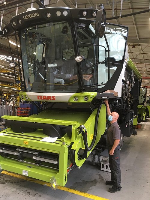 Mit Mundschutz und gebührendem Abstand zu den Kollegen arbeitet Dirk Ossenbrink an der Endmontage eines Lexion in der Mähdrescherproduktion. Der Konzern hat in den vergangenen Wochen alles getan, um die Bänder wieder laufen zu lassen.  - © Claas