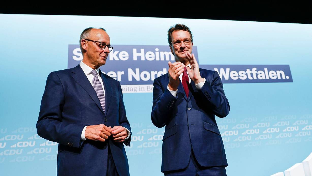 Bundeskanzler Friedrich Merz (l, CDU) steht nach seiner Rede beim Landesparteitag der CDU Nordrhein-Westfalen mit Hendrik Wüst (CDU), Ministerpräsident von Nordrhein-Westfalen, auf der Bühne. | © Thomas Banneyer/dpa