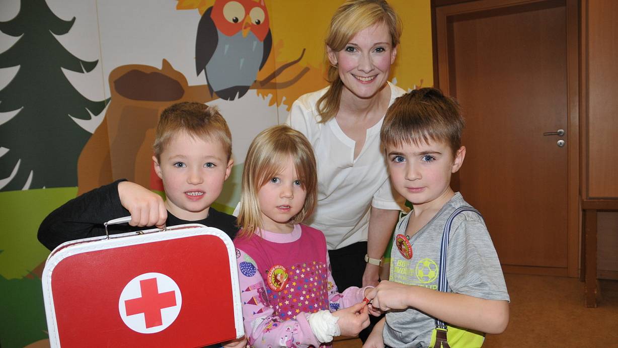 Autsch: Marlene klebt Samuel noch ein Pflaster auf den Finger. Moritz hätte bei Bedarf sogar einen Verband im Notfallkoffer. Trainerin Juliane Stöve vermittelt den Kindern einfache Erste-Hilfe-Maßnahmen und Unfallprävention. | © Frank Jasper