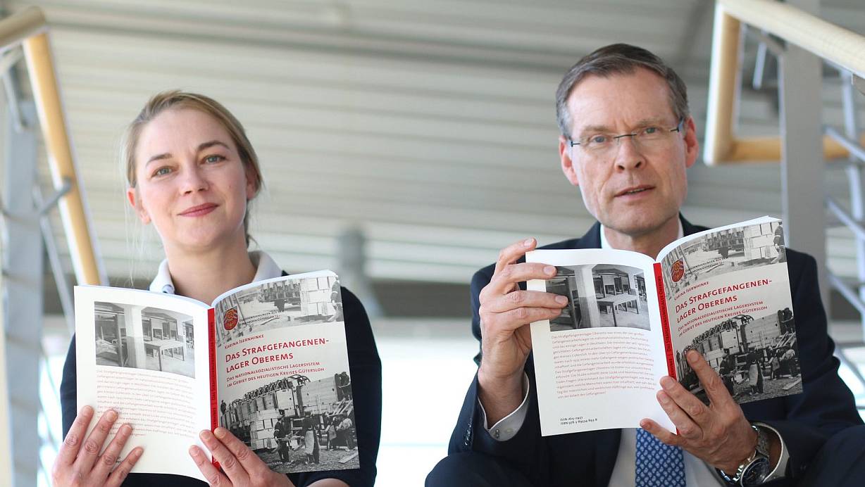 Informative Lektüre: Autorin Karina Isernhinke und Landrat Sven-Georg Adenauer mit dem 13. Band aus der Reihe Veröffentlichungen aus dem Kreisarchiv. Foto: Kreis Gütersloh | © Foto: Kreis Gütersloh