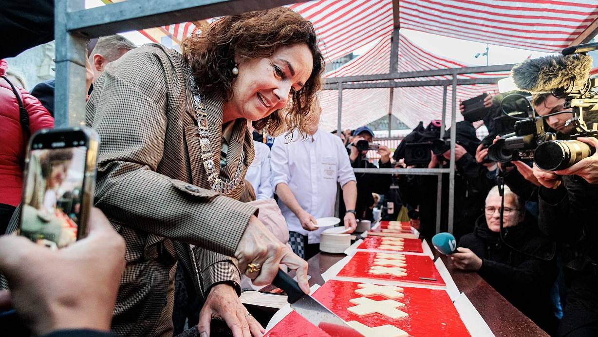 Amsterdams Bürgermeisterin Femke Halsema schneidet die lange Torte an. | © Ramon Van Flymen/ANP/dpa