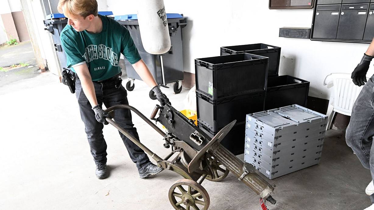 Polizisten transportieren ein Maschinengewehr ab. | © Roberto Pfeil/dpa