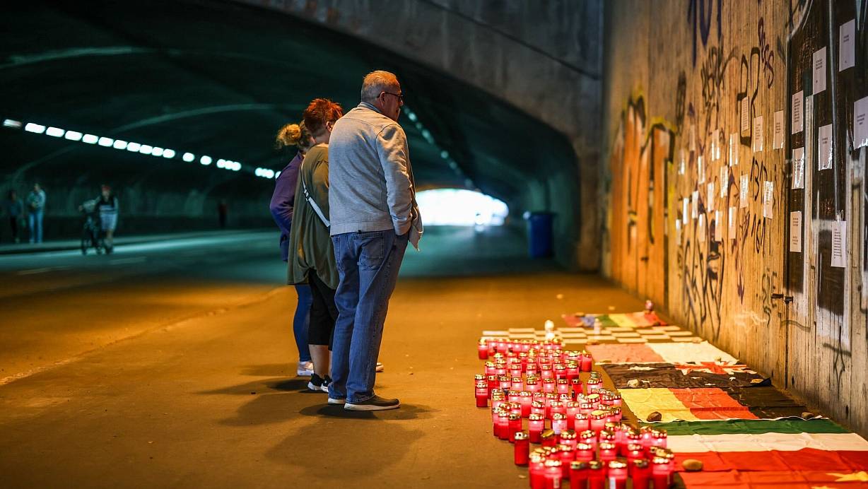 Betroffene stehen im Tunnel in der Nähe des Unglücksortes vor Kerzen, die das Datum 24.07.2010 zeigen. | © Christoph Reichwein/dpa