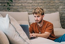 Ein Mann am Laptop auf einer Couch - Zacharie Scheurer/dpa-tmn Ein Mann am Laptop auf einer Couch - Zacharie Scheurer/dpa-tmn