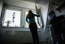 Frau öffnet zum Lüften ein Fenster - Christin Klose/dpa-tmn Frau öffnet zum Lüften ein Fenster - Christin Klose/dpa-tmn