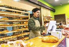 Verkäufer, der einen Touchscreen Computer benutzt... - picture alliance / imageBROKER