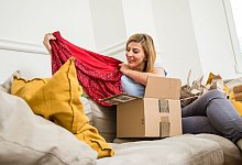 Eine Frau packt Klamotten aus - Christin Klose/dpa-tmn Eine Frau packt Klamotten aus - Christin Klose/dpa-tmn