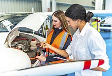 Zwei Ingenieurinnen inspizieren in einem Hangar ein Flugzeugtriebwerk... - picture alliance / imageBROKER