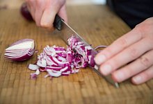 Frau schneidet Zwiebeln - Florian Schuh/dpa-tmn