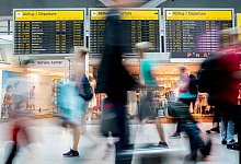 Passagiere laufen am Flughafen vor der Anzeigetafel - Christoph Soeder/dpa/dpa-tmn