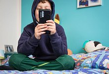 Kind hält Smartphone in den Händen - Christin Klose/dpa-tmn