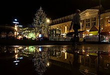 Ein Weihnachtsbaum spiegelt sich in einer Pfütze - Marijan Murat/dpa/dpa-tmn