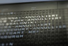 Eine Anzeigetafel weist auf ausgefallenen Flüge hin - Frank Rumpenhorst/dpa-tmn