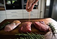 Eine Perosn würzt Fleisch - Andreas Arnold/dpa/dpa-tmn Eine Perosn würzt Fleisch - Andreas Arnold/dpa/dpa-tmn