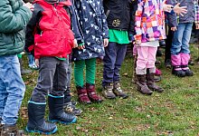 Kinder stehen in einem Garten - Jens Büttner/dpa/dpa-tmn