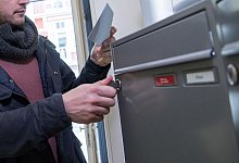 Ein Mann holt einen Brief aus dem Briefkasten - Christin Klose/dpa-tmn