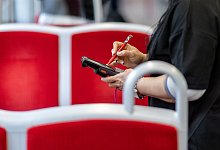 Eine Fahrkartenkontrolleurin kontrolliert einen Fahrgast - Daniel Karmann/dpa/dpa-tmn