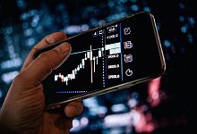 Mann schaut sich Aktienkurse auf dem Smartphone an - Zacharie Scheurer/dpa-tmn Mann schaut sich Aktienkurse auf dem Smartphone an - Zacharie Scheurer/dpa-tmn