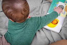 Ein sieben Monate altes Baby spielt auf einer Decke - Jessica Kliem/dpa-tmn