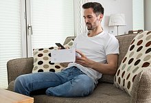 Mann liest seine Post - Christin Klose/dpa-tmn Mann liest seine Post - Christin Klose/dpa-tmn