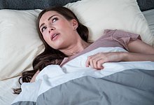 Eine junge Frau liegt wach in ihrem Bett - Christin Klose/dpa Themendienst/dpa-tmn